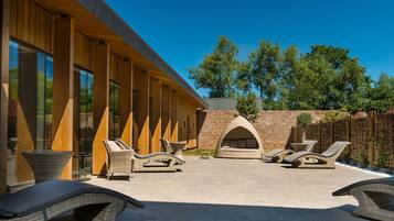 A spa area with wooden walls, large windows, and outdoor seating.