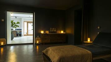 Une chambre à coucher moderne avec un lit, des lampes de chevet, une commode et un miroir.