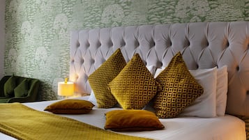 A neatly made bed with a tufted headboard, multiple pillows, and a bedside lamp.