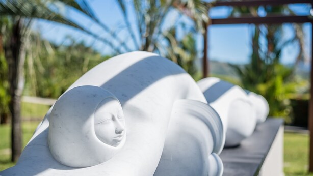 A row of white, abstract sculptures in an outdoor setting. - Hotel Palma de Oro (Bejuco)