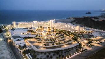 Un hotel grande con varias secciones, un patio central y vista al océano.