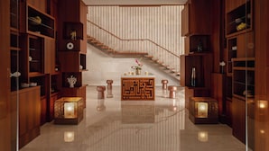A modern interior with a wooden staircase, built-in shelves, and decorative lighting. - InterContinental Fujairah Resort by IHG (Al Aqah)