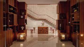 A modern interior with a wooden staircase, built-in shelves, and decorative lighting.