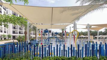 A water play area with colorful structures and a covered seating area.