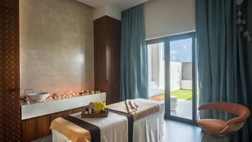Relax in a serene spa room with a large oval-shaped bathtub, wooden bench, and outdoor area.