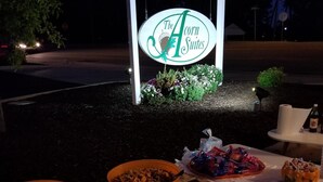 Mesa posta com diversos pratos e um letreiro com a inscrição "The Corn Suites" ao fundo.