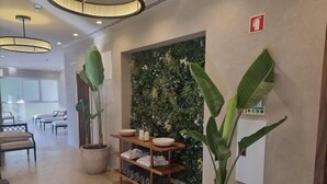 A reception area with a wooden shelf holding towels and a potted plant. - Estalagem De Santa Iria (Tomar)