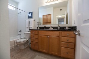 A bathroom with a toilet, sink, vanity, and shower. - Kierland Villa By Signature Vacation Rentals (Scottsdale)