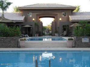 Un hôtel doté d’une piscine, d’un espace extérieur aménagé et d’une façade en pierre.