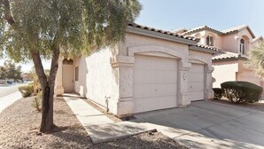 A residential house with a beige exterior, a garage, and a driveway. - Keep It Simple By Signature Vacation Rentals (Glendale)