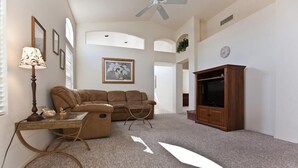 A living room with a brown sofa, a glass coffee table, a wooden cabinet, and a ceiling fan. - Keep It Simple By Signature Vacation Rentals (Glendale)