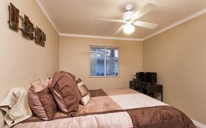 A bedroom with a bed, a desk, a ceiling fan, and a window with blinds. - Just Darling By Signature Vacation Rentals (Phoenix)