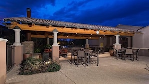 An outdoor patio with wooden pergola, stone pillars, and outdoor seating. - Hot Spot at Desert Ridge By Signature Vacation R (Phoenix)