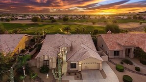 A residential area with houses featuring red-tiled roofs and a golf course in the background. - Hole in One By Signature Vacation Rentals (Goodyear)