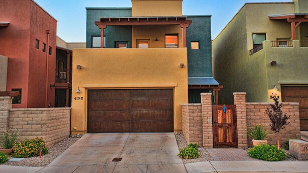 A modern residential building with a garage, a balcony, and a small garden area. - Heart of Tucson By Signature Vacation Rentals (Tucson)