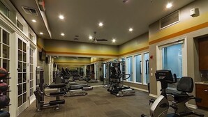 Ein Fitnessstudio mit Laufbändern, Crosstrainern und Gewichten.