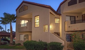 A multi-story building with a flat roof, large windows, and a staircase leading to the upper floor. - Happy Ours By Signature Vacation Rentals (Paradise Valley)