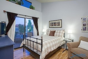 A bedroom with a bed, bedside table, and a window with curtains. - Happy Ours By Signature Vacation Rentals (Paradise Valley)