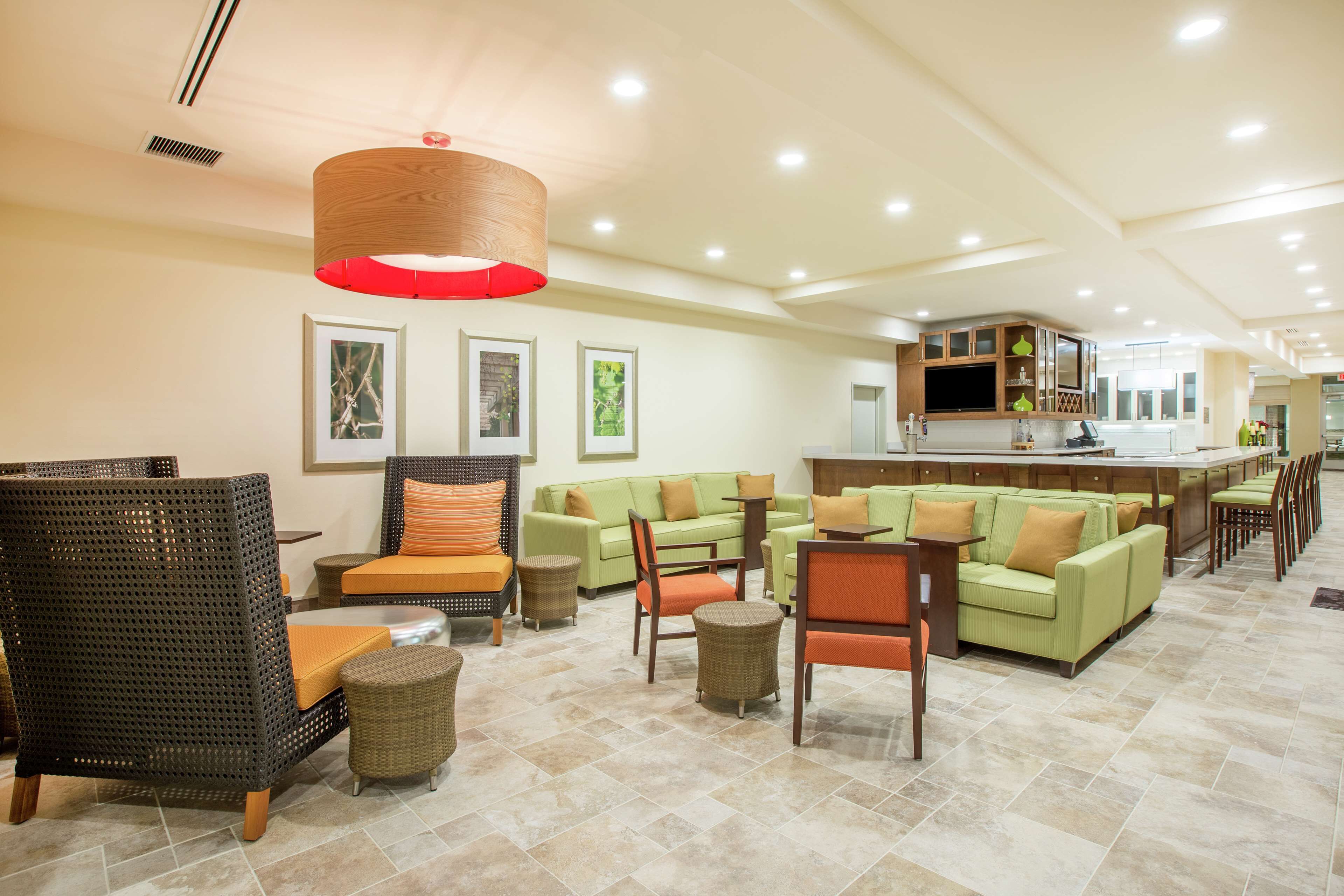 A spacious lobby with seating areas, a kitchen, and a bar.
