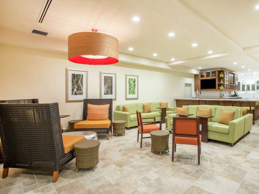 A spacious lobby with seating areas, a kitchen, and a bar.