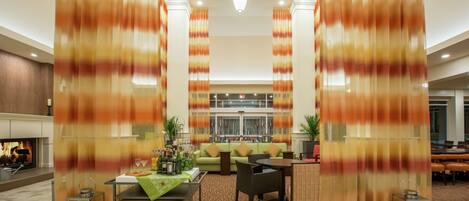 A spacious lobby with a fireplace, seating area, and a view of the lobby in the background.