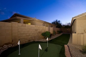 A residential property with a paved driveway, a small lawn, and a brick wall. - Estrella Mountain By Signature Vacation Rentals (Goodyear)