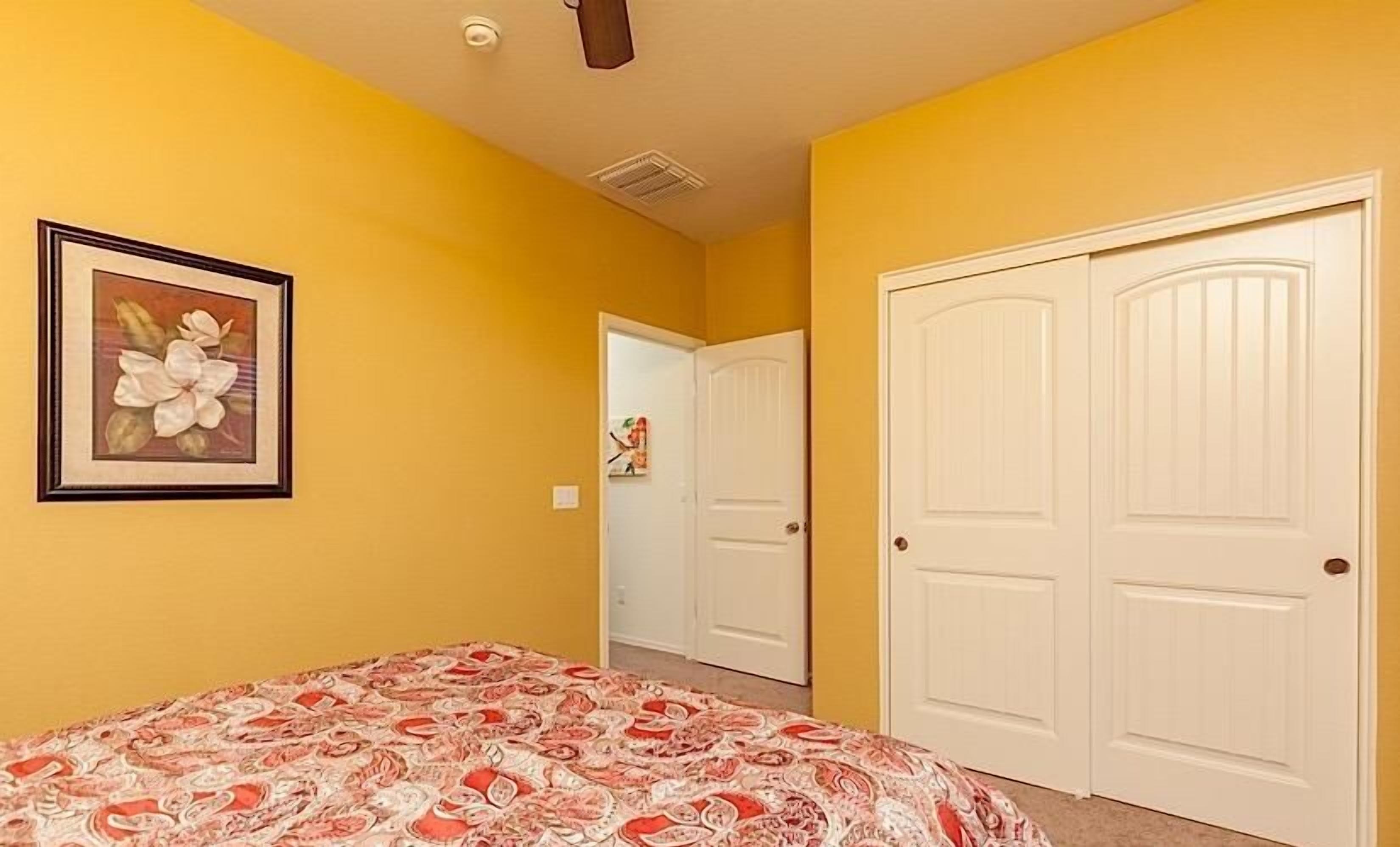 A bedroom with a bed, a door, and a hallway.