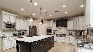 Una cocina moderna con armarios blancos, electrodomésticos de acero inoxidable y una isla grande.