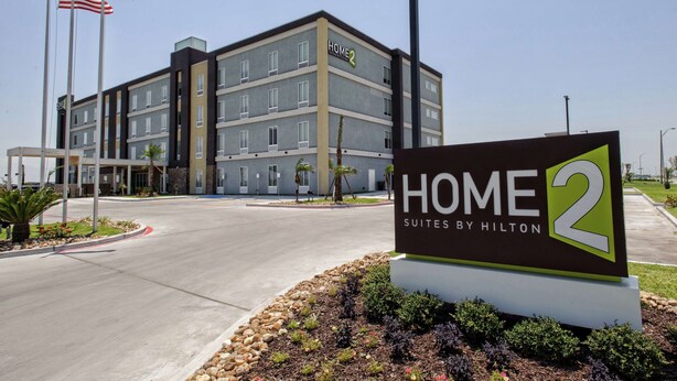A hotel named "Home 2 Suites by Hilton" with a modern building facade, multiple floors, and a landscaped entrance area. - Home2 Suites by Hilton Portland (Portland)