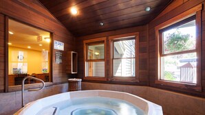 A spa with a hot tub, wooden walls, and large windows. - The Lodge at Steamboat (Steamboat Springs)