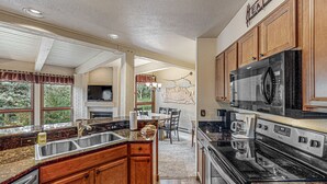 A modern kitchen with granite countertops, wooden cabinets, and stainless steel appliances. - The Lodge at Steamboat (Steamboat Springs)
