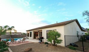 A single-story house with a patio, a pool, and a barbecue area.
