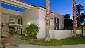 A modern two-story house with a balcony, a paved driveway, and a well-maintained lawn with palm trees. - Ultra Chic and Modern By Signature Vacation Rentals (Scottsdale)