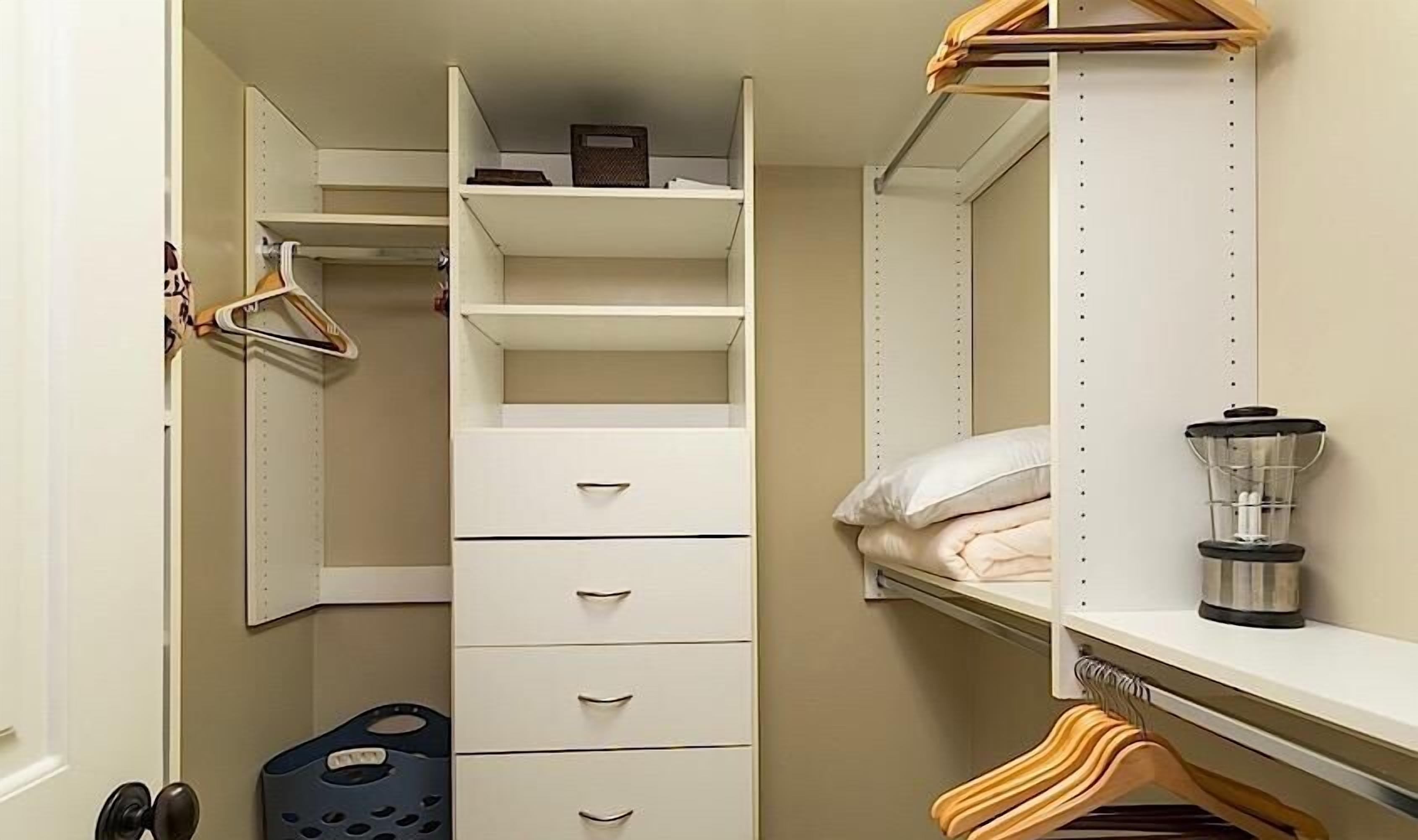 Een kast met open planken, hangruimte en lades.