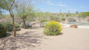 A fenced outdoor area with a pool, various shrubs, and cacti. - Troon Skyline Private By Signature Vacation Rental (Scottsdale)