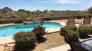 Una piscina con vistas a un paisaje rocoso y una montaña al fondo.