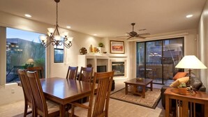 Un espacio habitable amplio con mesa y sillas de comedor, chimenea y ventilador de techo.