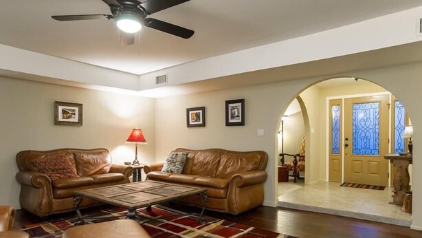 A living room with two leather sofas, a coffee table, and a patterned rug. - Thunderbird By Signature Vacation Rentals (Scottsdale)