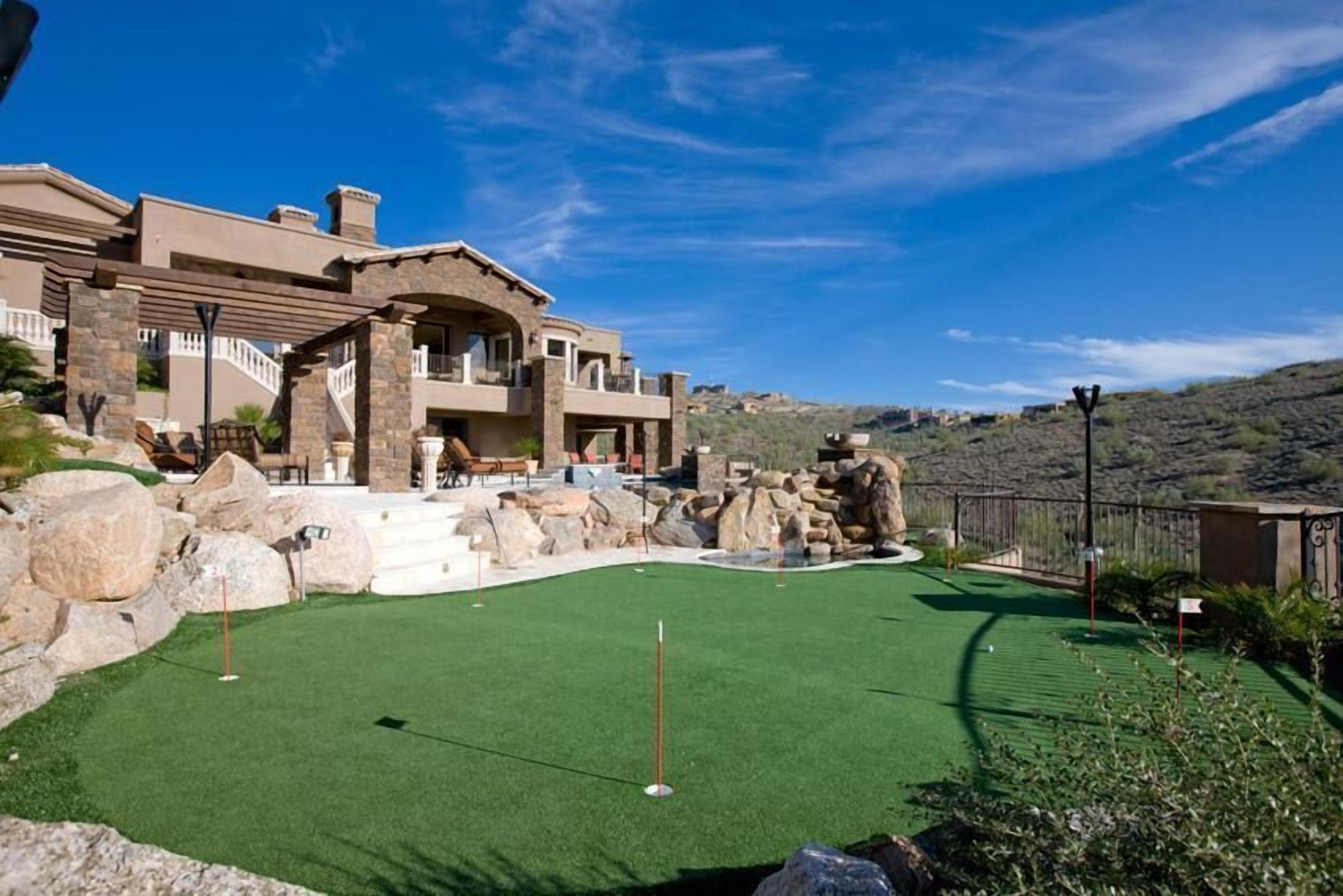 Un campo de golf con una casa al fondo.