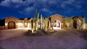 A desert-style building with arched doorways and cacti landscaping. - Bella Estate By Signature Vacation Rentals (Scottsdale)