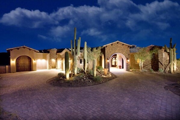 A desert-style building with arched doorways and cacti landscaping.