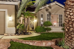 A residential house with a well-maintained lawn, a stone pathway, and a palm tree. - Augusta On The Green by Signature Vacation Rentals (Mesa)