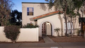 A modern building with a flat roof, a large window, and an arched entrance. - Arizona Grande By Signature Vacation Rentals (Phoenix)