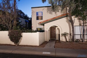 A modern two-story building with a central entrance, a small porch, and a covered walkway leading to the door. - Arizona Grande By Signature Vacation Rentals (Phoenix)
