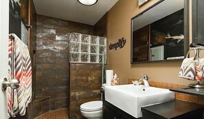 Un bagno con doccia, WC e lavandino.