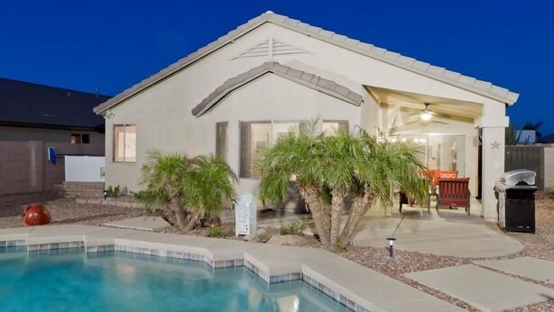 A single-story house with a swimming pool, a covered patio, and a small garden with palm trees. - All Star By Signature Vacation Rentals (Chandler)