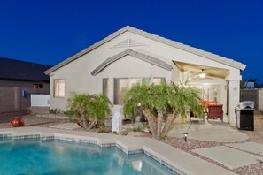 A single-story house with a swimming pool, a covered patio, and a small garden with palm trees. - All Star By Signature Vacation Rentals (Chandler)