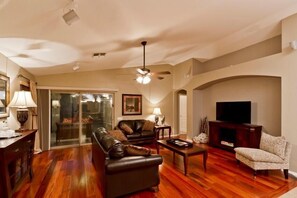 A living room with a fireplace, leather sofas, a coffee table, and a television. - All Star By Signature Vacation Rentals (Chandler)