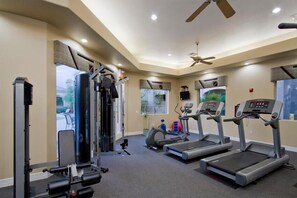 A home gym with treadmills, a weight bench, and a rowing machine.
