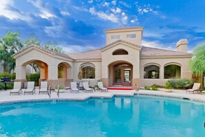 A large house with a swimming pool, multiple arches, and a red carpet leading to the entrance. - Acacia Loft By Signature Vacation Rentals (Cave Creek)
